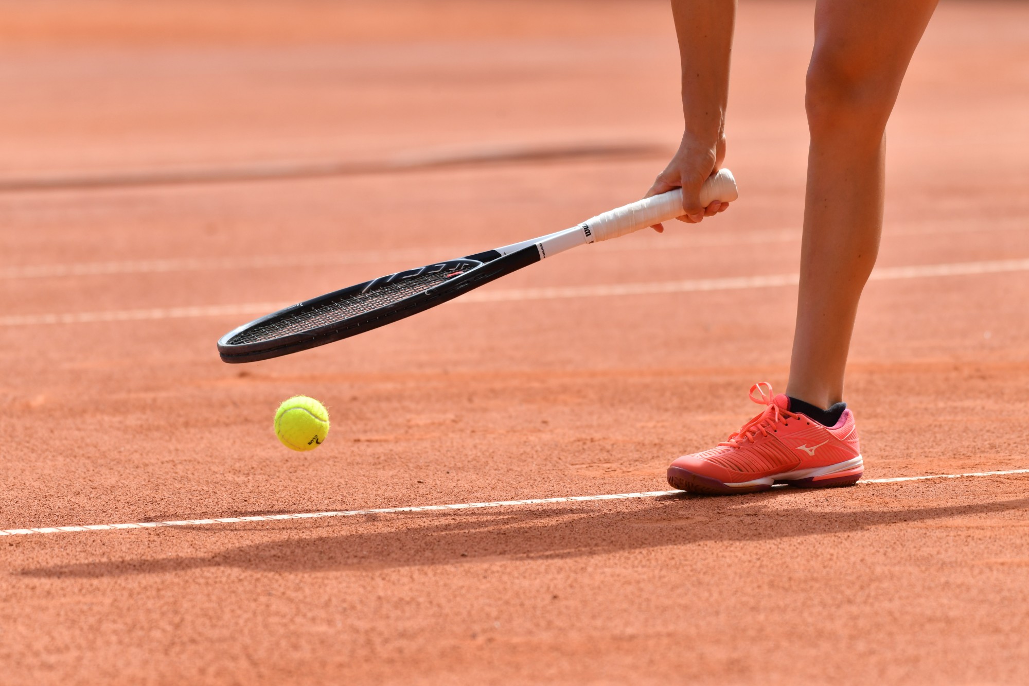 Zawodniczka w trakcie serwisu na korcie ceglanym Yankee Tennis Club